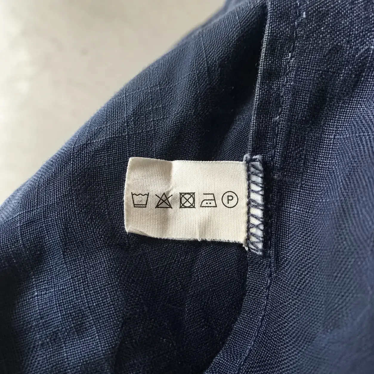 Care label u bočnom šavu sa simbolima pranja na lanenoj košulji